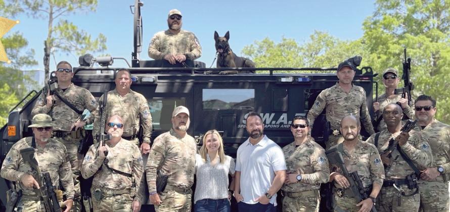 Dr. Elizabeth Dickinson and Dr. David Bulot pose for a photo with PPSO SWAT Team and K9 Vader.