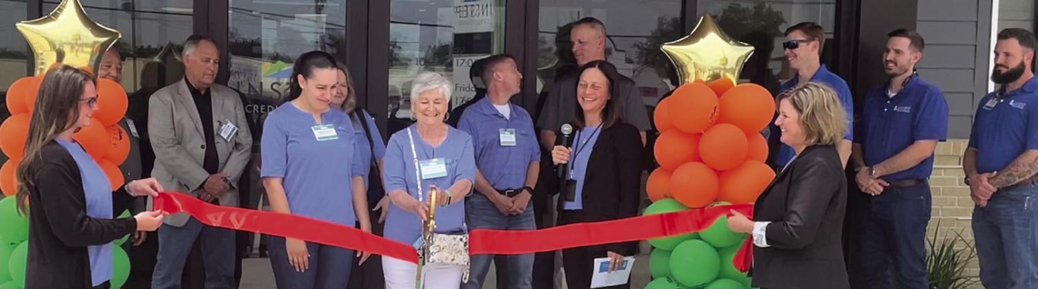 Parish President Keith Hinkley and Instep Credit Union board members and staff watch the ribbon cutting.