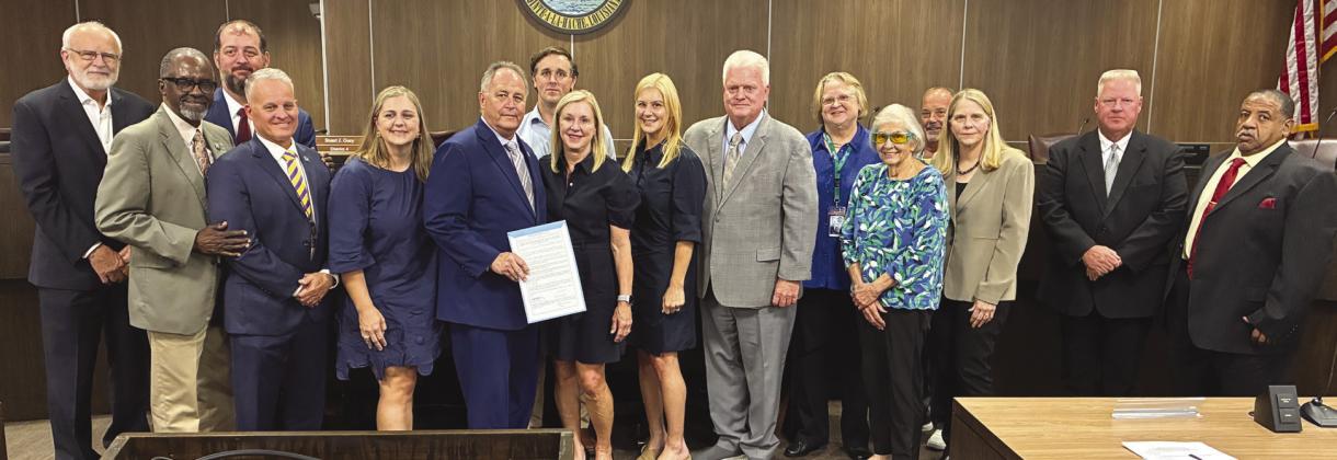 Parish President Keith Hinkley and parish council members present the Cossich family with a proclamation honoring the life and legacy of Philip Cossich Jr., a prominent parish lawyer and a respected community member.
