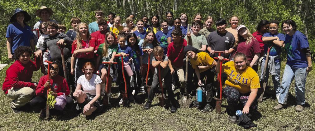 Belle Chasse Middle School students pose for a group photo after planting 363 native trees in Port Sulphur - the rewarding culmination of their . rst year participating in the LSU Coastal Roots Program.
