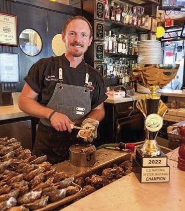 Jordan Gallet, Master Shucker at Superior Seafood & Oyster Bar, poses for a photo on November 4 with his National Oyster Shucking Champion trophy.