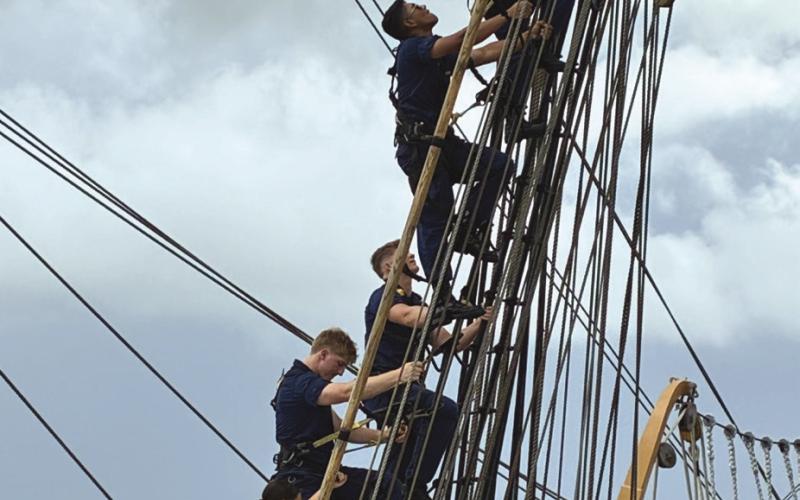 Some members of the crew climb up the USCGC Eagle's rigging.