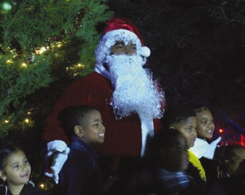 Santa visits the children in Port Sulphur and assists in lighting the tree in front of the Government Building.