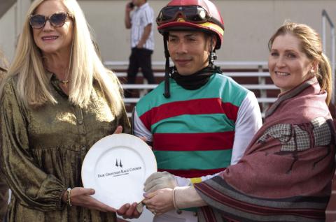 Five time Champion Jockey of the New Orleans Fairgrounds, Rosie Napravnik returned to the Winner's Circle for the 2025 season in her new vocation raising awareness of a program for retired racehorses. Pictured here with Jockey Jose Ortiz, Rosie presents the winners plate in honor of winning horse Montalcino.