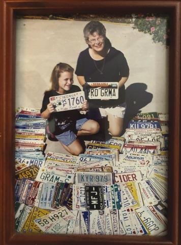 Abbey and Grandmother Glenda with some of license plates donated.