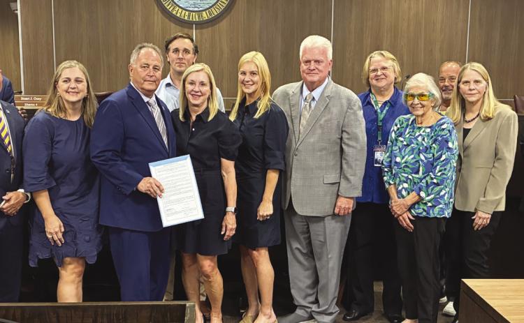 Parish President Keith Hinkley and parish council members present the Cossich family with a proclamation honoring the life and legacy of Philip Cossich Jr., a prominent parish lawyer and a respected community member.