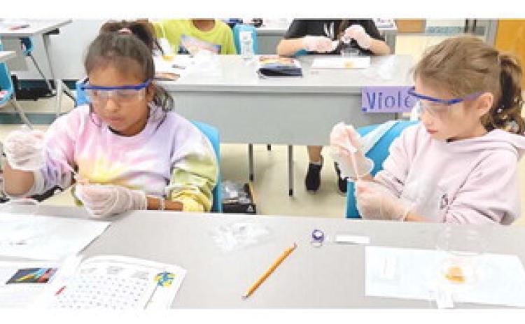 The STEAM Department at Nunez Community College will o er more than 10 multi-day camps for young students this summer. Pictured, students conduct an experiment in a past Astro Camp at Nunez.