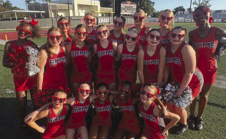 The cheer team on the sidelines getting ready to cheer on the bulldog football team.