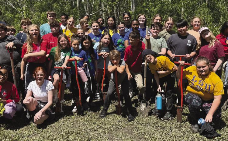 Belle Chasse Middle School students pose for a group photo after planting 363 native trees in Port Sulphur - the rewarding culmination of their . rst year participating in the LSU Coastal Roots Program.