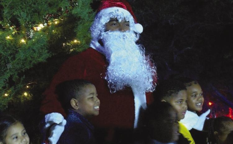 Santa visits the children in Port Sulphur and assists in lighting the tree in front of the Government Building.