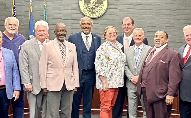 Commissioners pose for a photo with Tillotson after he signs new contract.
