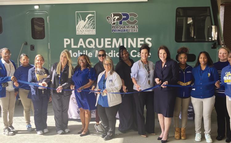 Phoenix High School Students, leadership with the Plaquemines Medical Center and Plaquemines Primary Care, School board member for district 1 Darilyn Demolle Turner, and Superintendent Shelley Ritz take part in the ribbon cutting to ocially announce the opening of the new Mobile Medical Unit