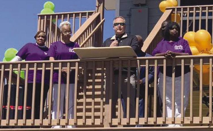 Parish president Keith Hinkley speaks during celebration of the reconstruction of . ve Ironton homes with members of the Ironton Reconstruction and Development Committee (IRAD) standing by his side.